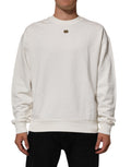 Sweatshirt blanc Dolce & Gabbana avec logo DG, col ras du cou, en coton, porté sur un mannequin.