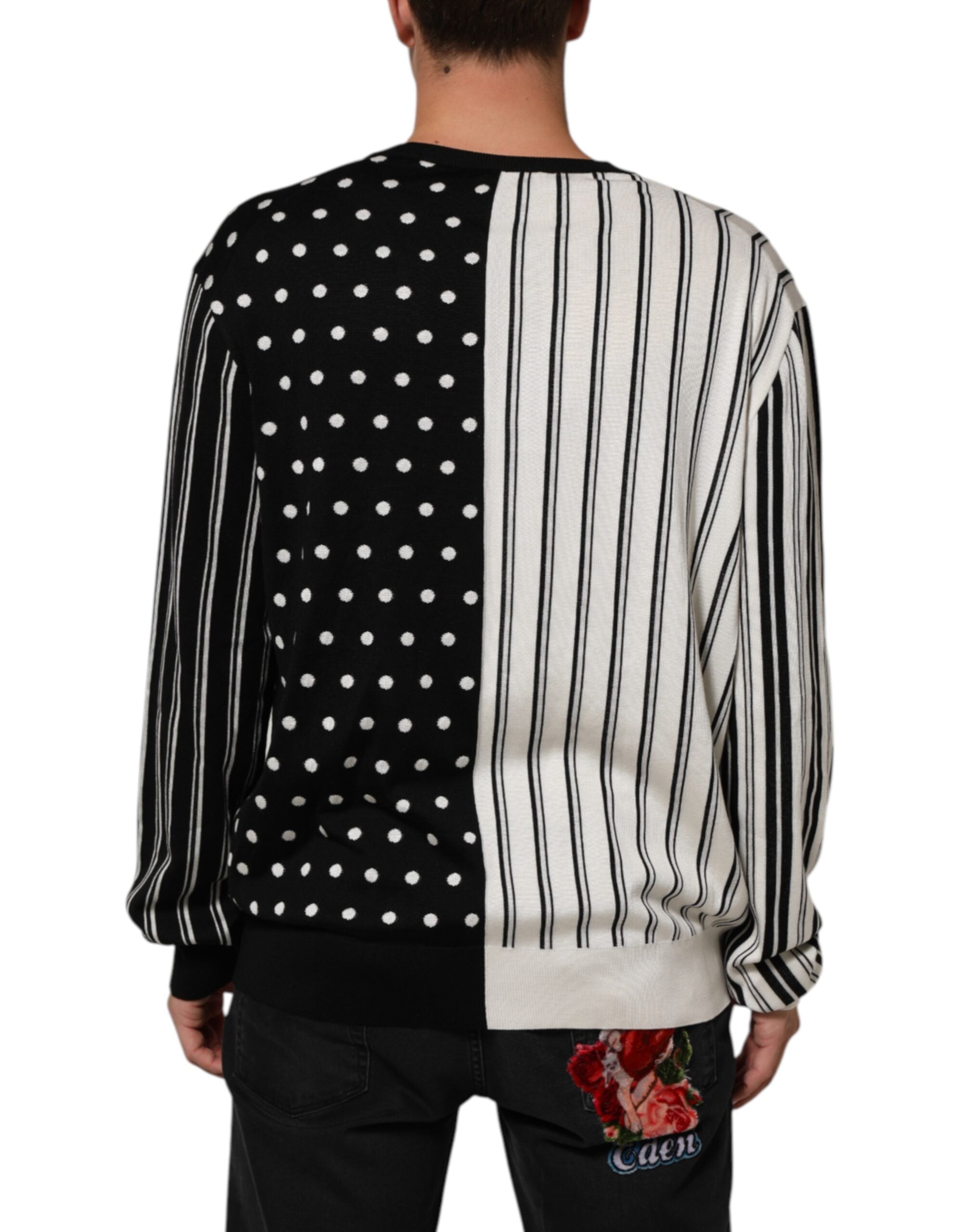 Pull en laine Dolce & Gabbana à rayures noires et blanches avec col en V et motifs à pois, porté ou posé sur un fond neutre.