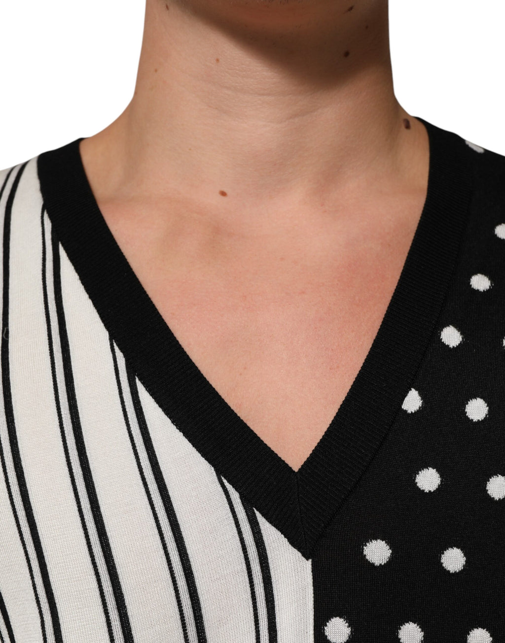 Pull Dolce & Gabbana en tricot noir et blanc avec rayures et pois, col en V, vue de face.
