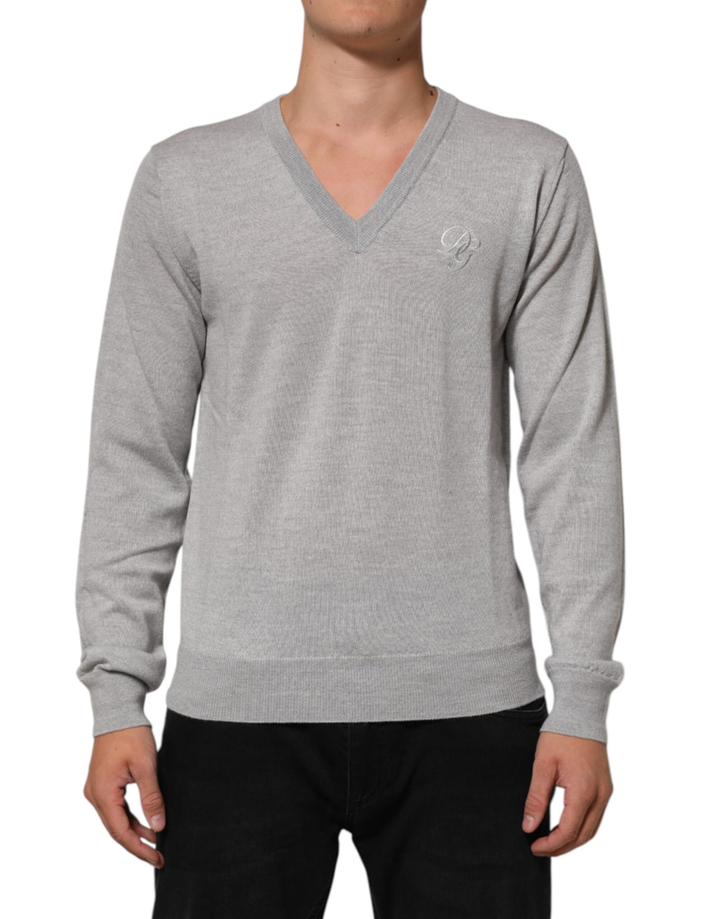 Pull à col en V en laine gris Dolce & Gabbana avec logo tricoté, porté sur un mannequin.