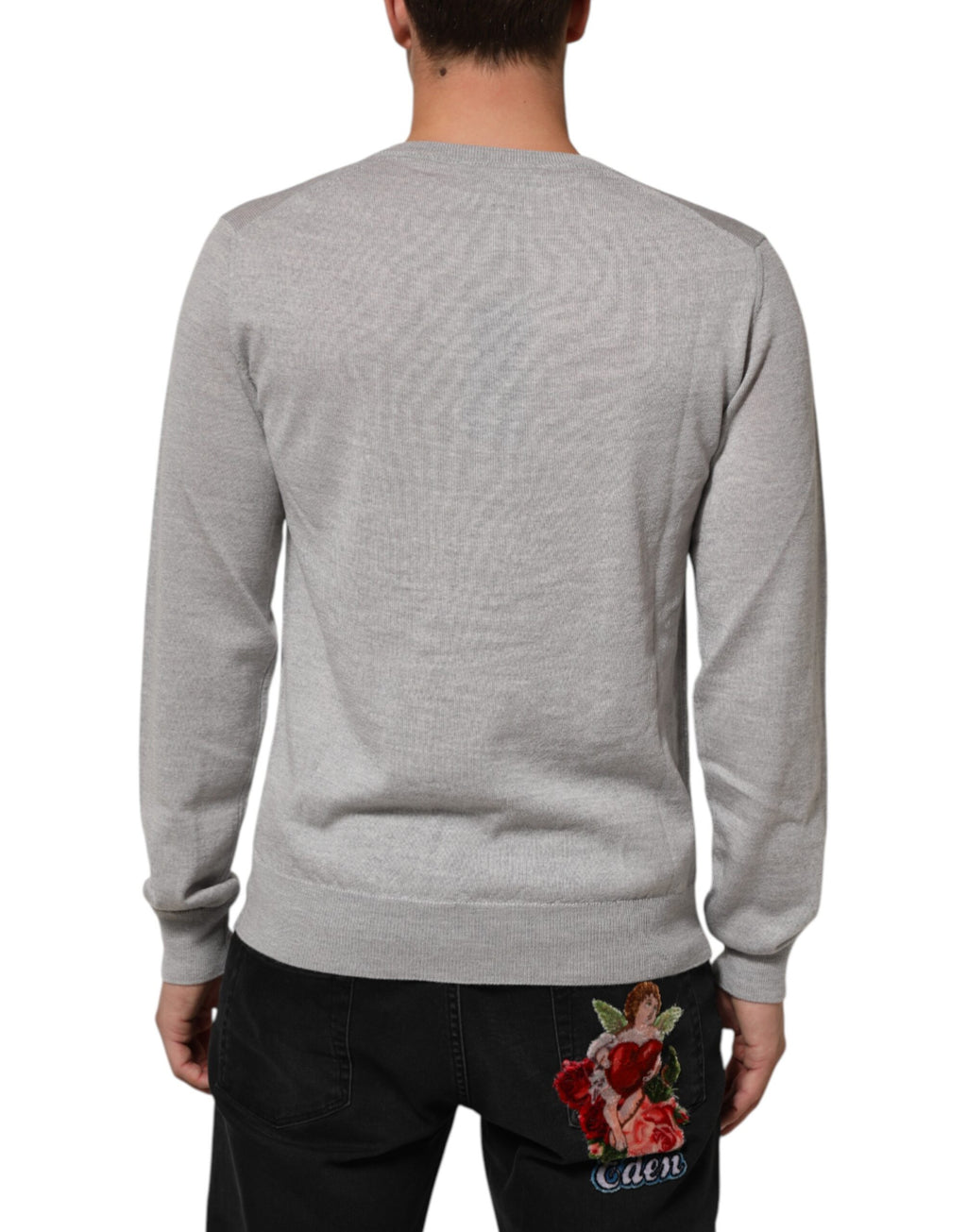 Pull en laine gris Dolce & Gabbana à logo, col en V et coupe décontractée, visible sur l'image.