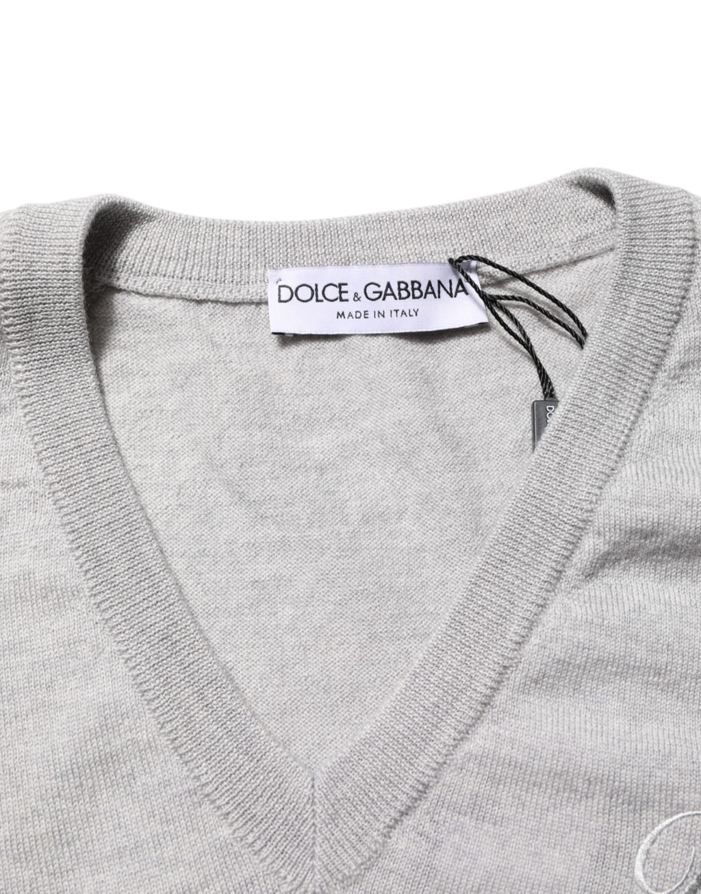 Pull en laine gris Dolce & Gabbana avec logo en V-neck, douceur et style élégant visible sur l'image.