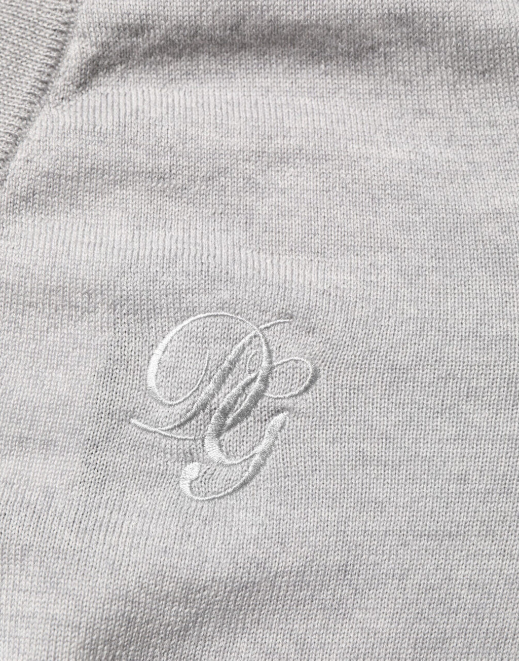 Pull en laine gris Dolce & Gabbana avec logo, col en V, style confortable et élégant, visible sur le mannequin.