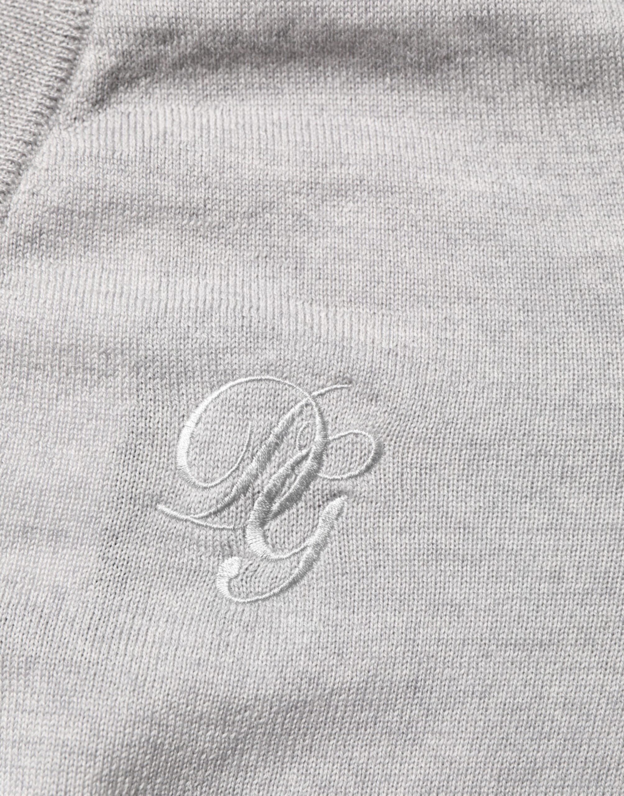 Pull en laine gris Dolce & Gabbana avec logo, col en V, style confortable et élégant, visible sur le mannequin.