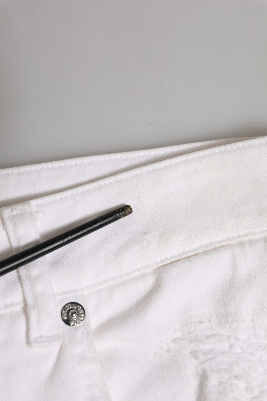 Jeans boyfriend en coton blanc Dolce & Gabbana avec déchirures et style décontracté, visibles en détail.