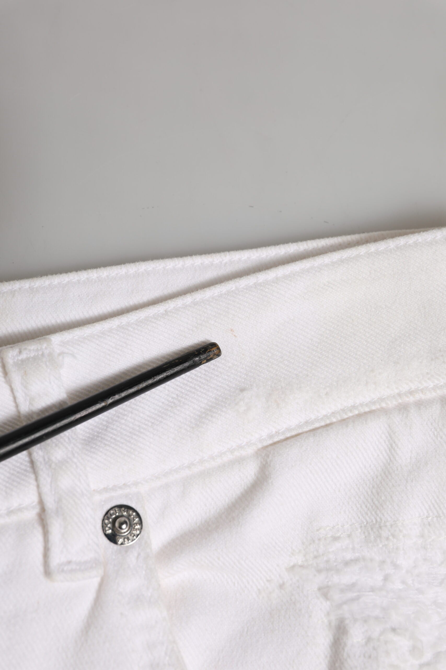 Jeans boyfriend en coton blanc Dolce & Gabbana avec déchirures et style décontracté, visibles en détail.