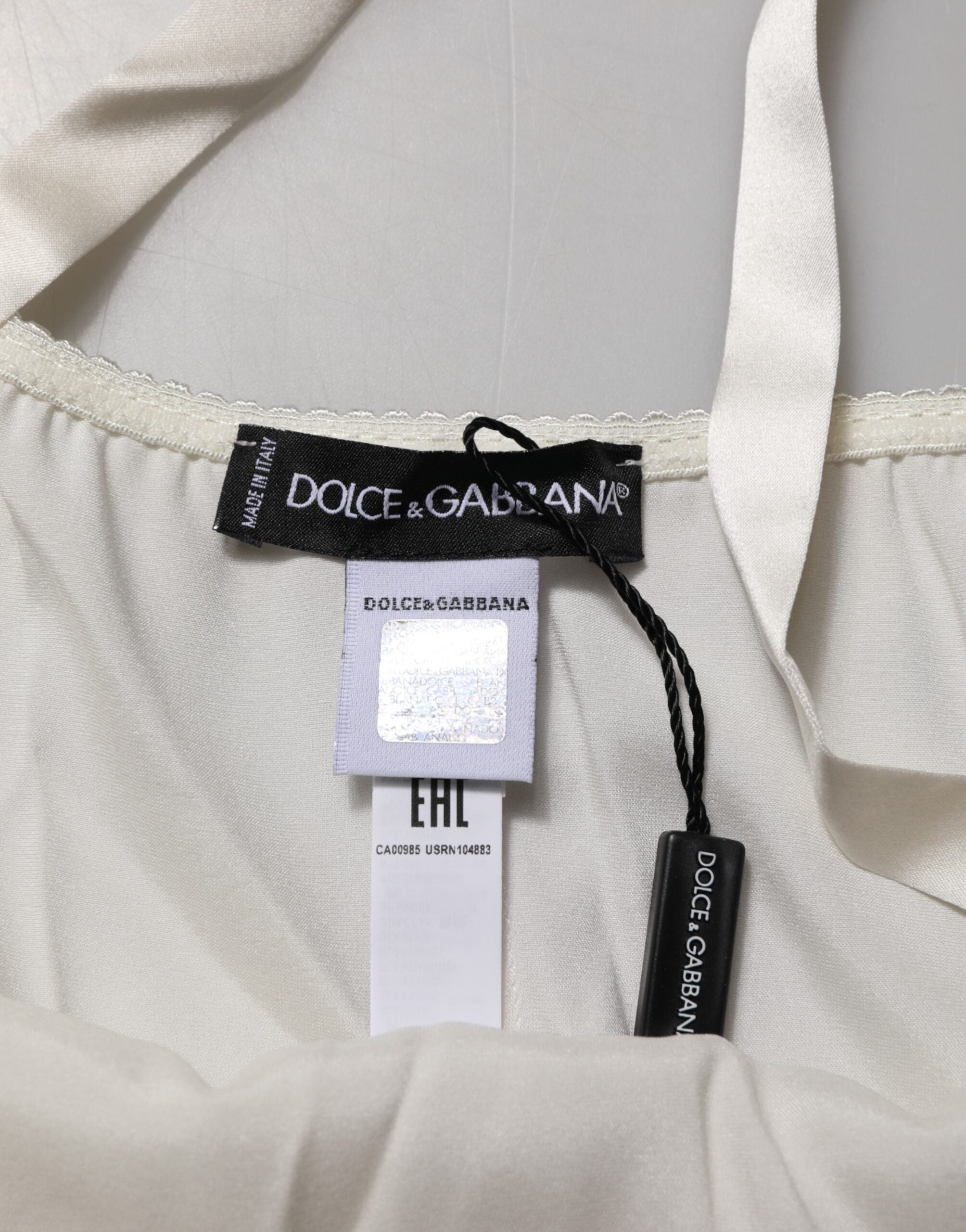 Top en lingerie Dolce & Gabbana en dentelle florale blanche, sans manches, avec détails délicats et élégants.