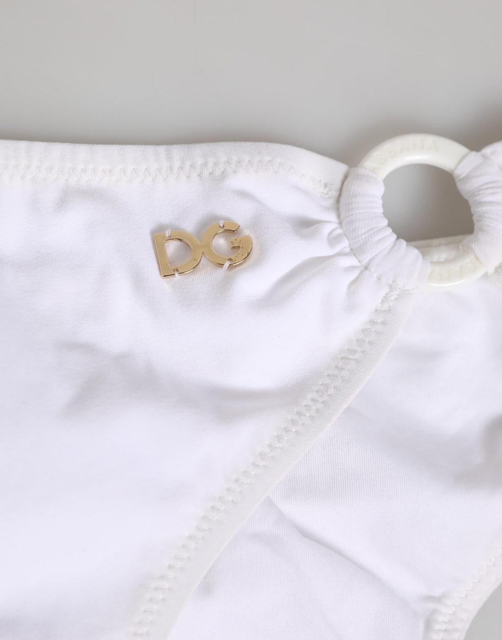 Maillot de bain deux pièces blanc Dolce & Gabbana avec logo, haut et bas, vue en gros plan.