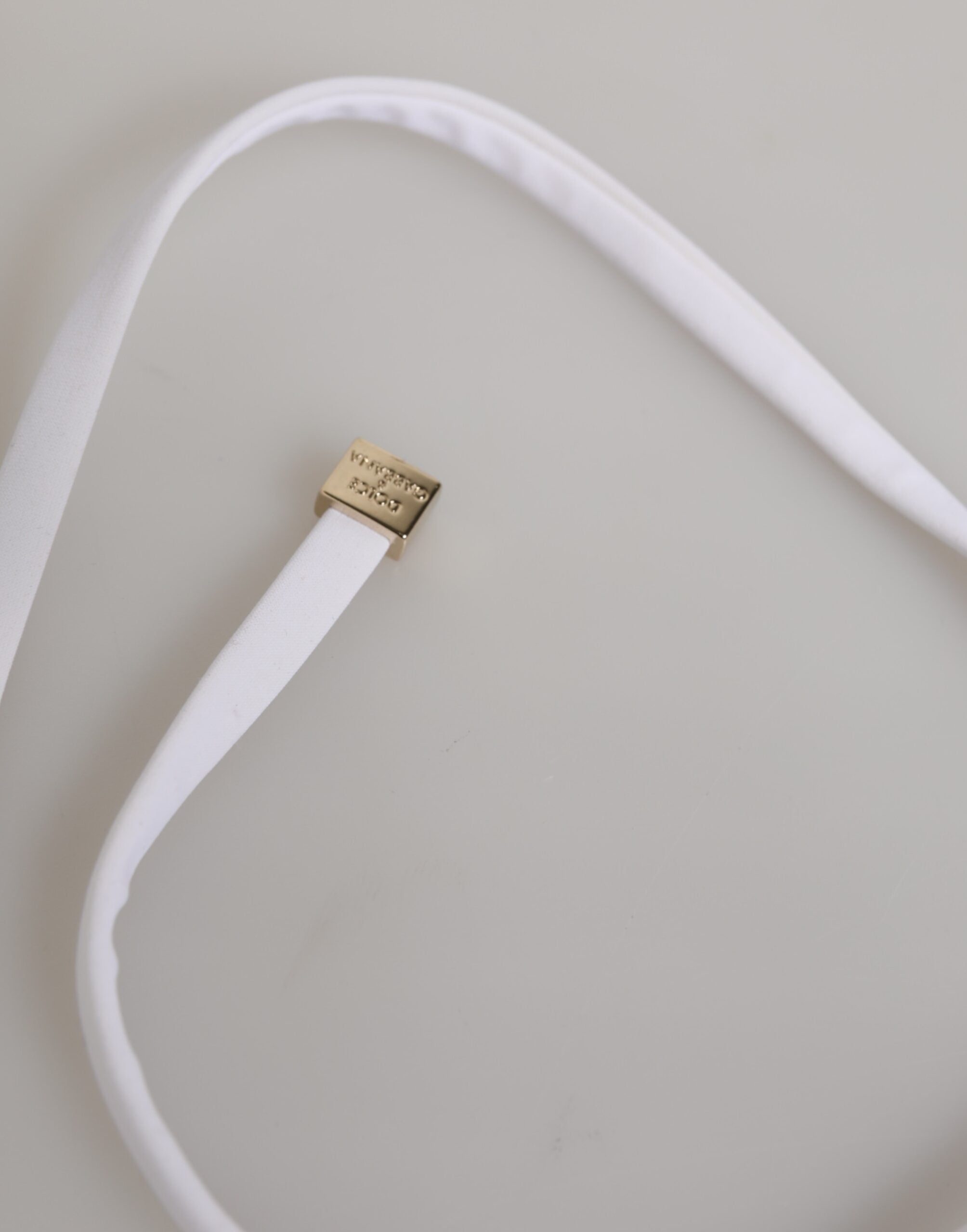 Maillot de bain deux pièces Dolce & Gabbana blanc avec logo, haut et bas visibles, tissu élégant et design tendance.