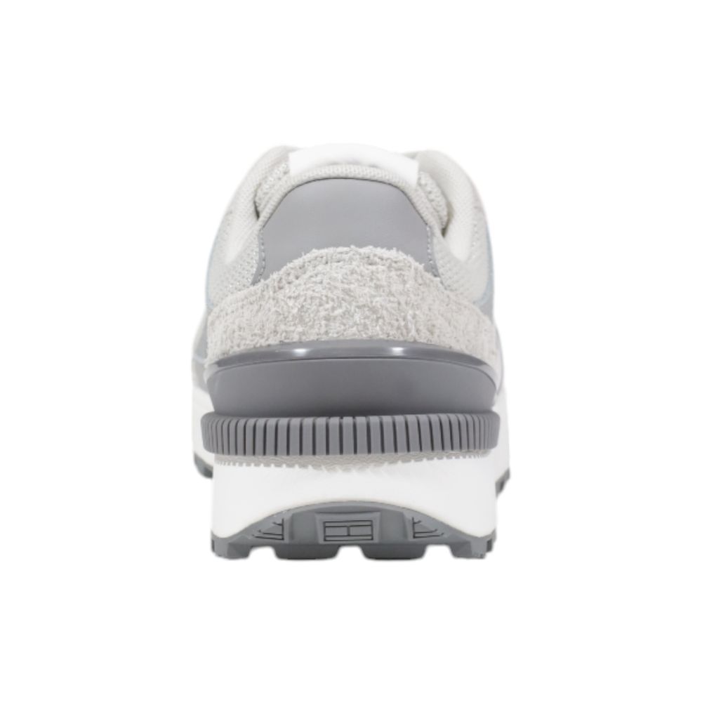 Sneakers athlétiques en cuir suédé gris de Tommy Hilfiger Jeans, avec design sportif et semelle blanche visible.