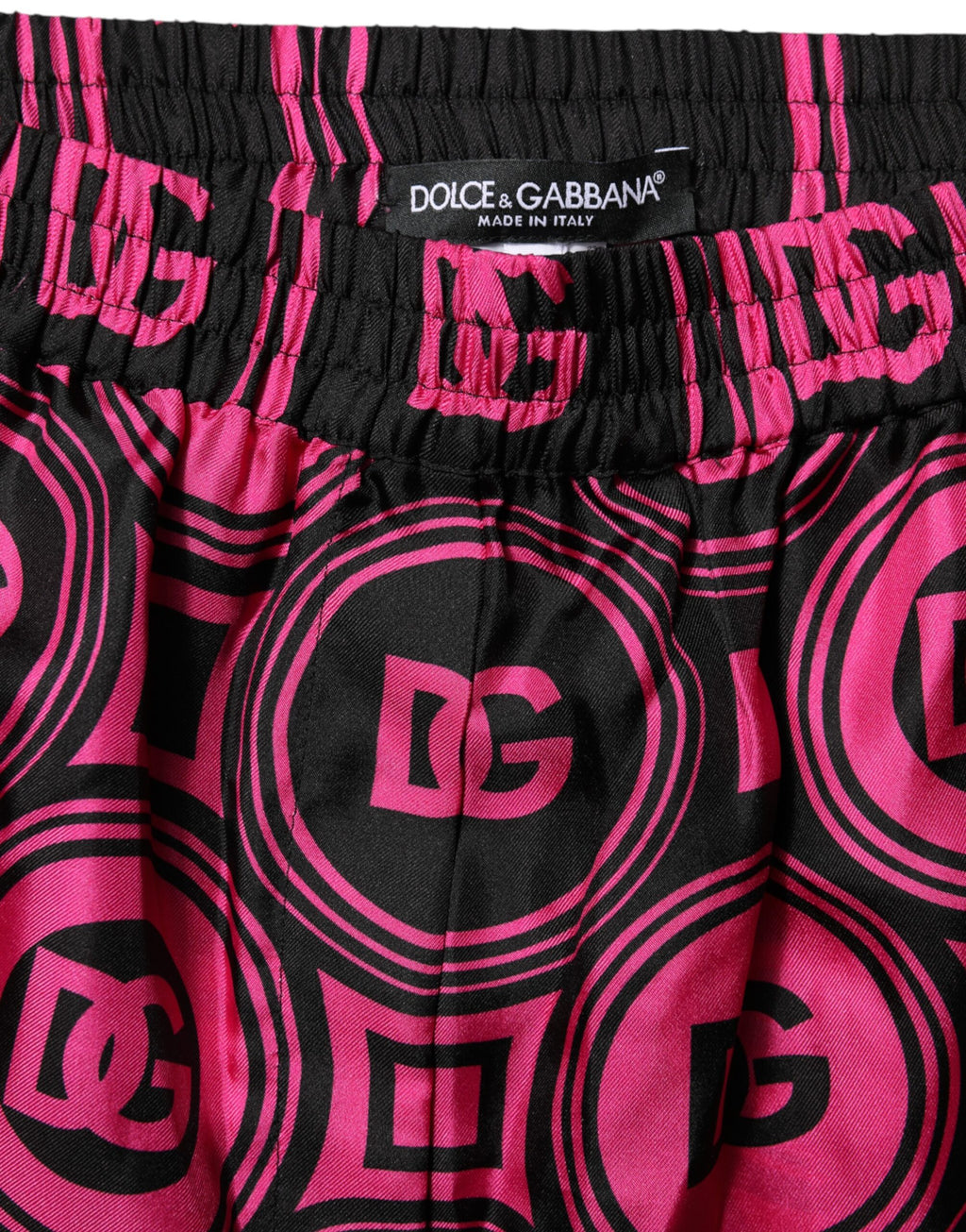 Shorts en soie rose et noire Dolce & Gabbana avec logo et motif DG, style élégant et tendance.