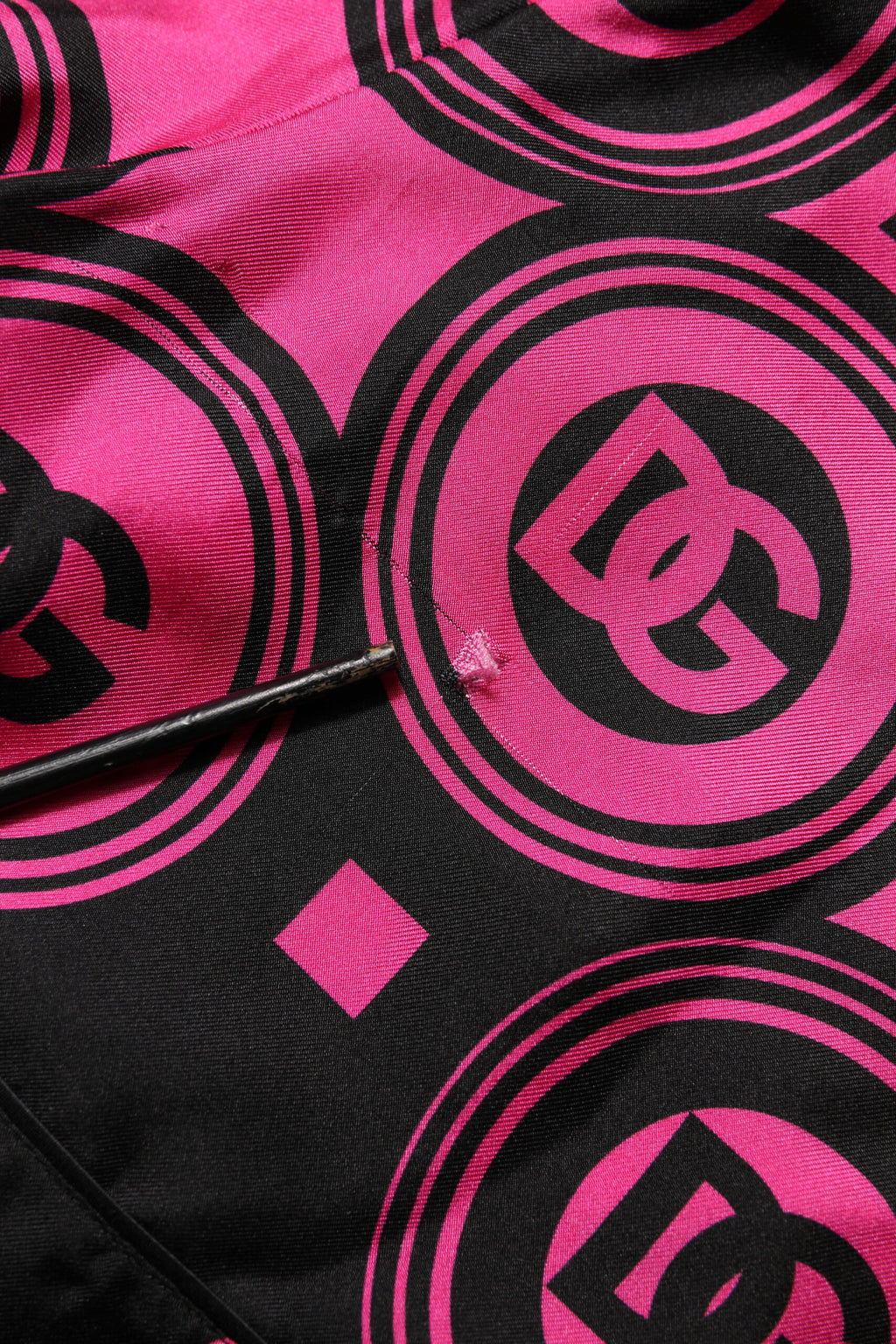 Shorts en soie rose et noire Dolce & Gabbana avec logo et motif DG, style élégant et tendance.