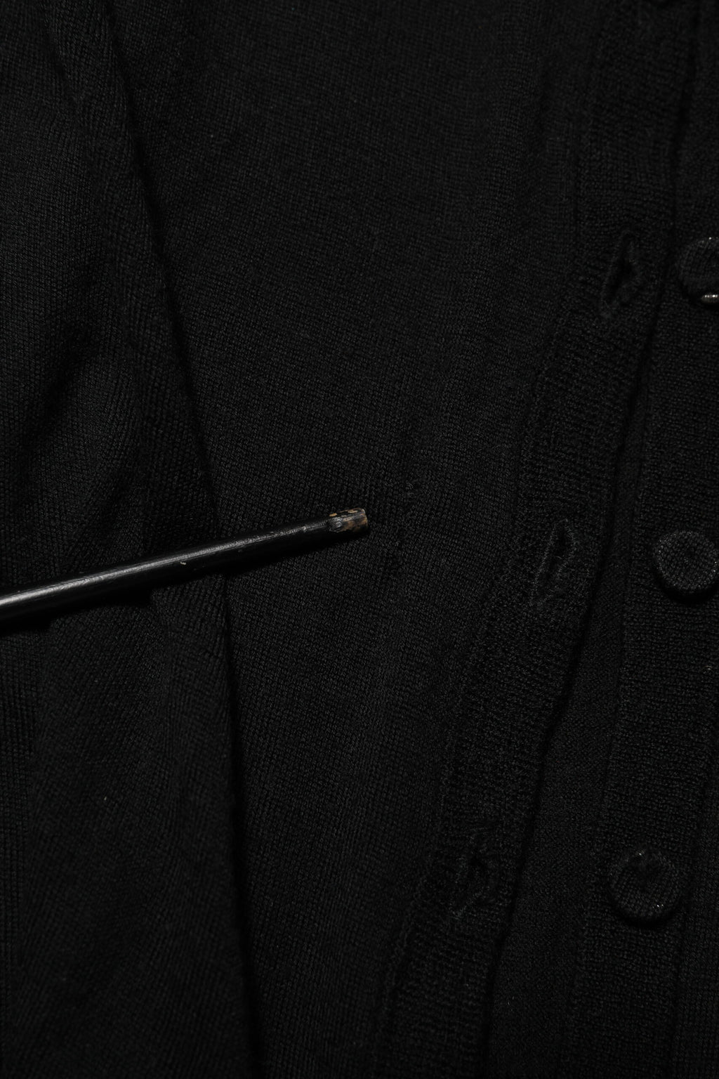Cardigan noir en laine vierge Dolce & Gabbana avec boutons, porté sur un mannequin, détails du tricot et coupe élégante.