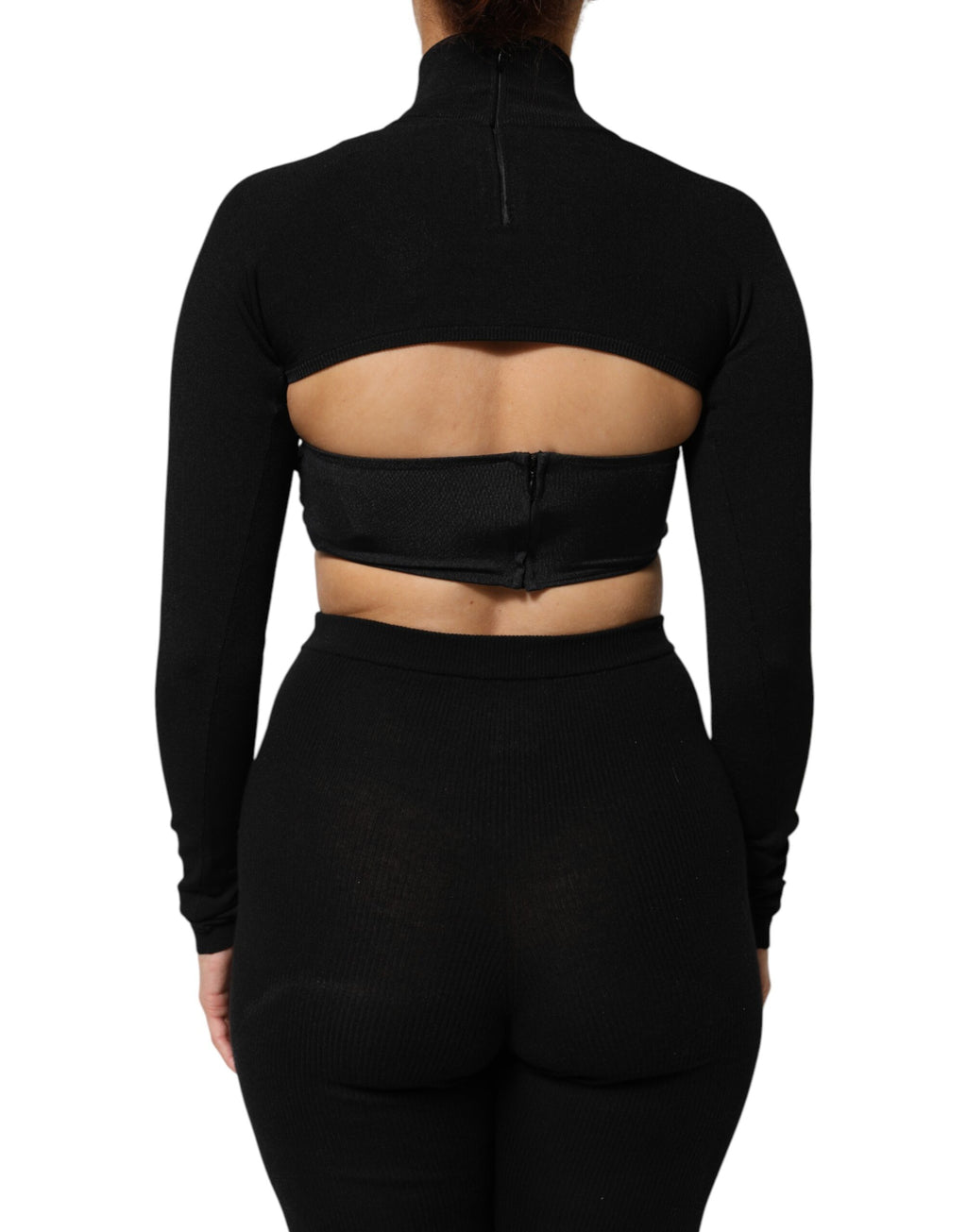 Pull noir Dolce & Gabbana à col roulé en viscose, coupe courte, porté sur un fond neutre.