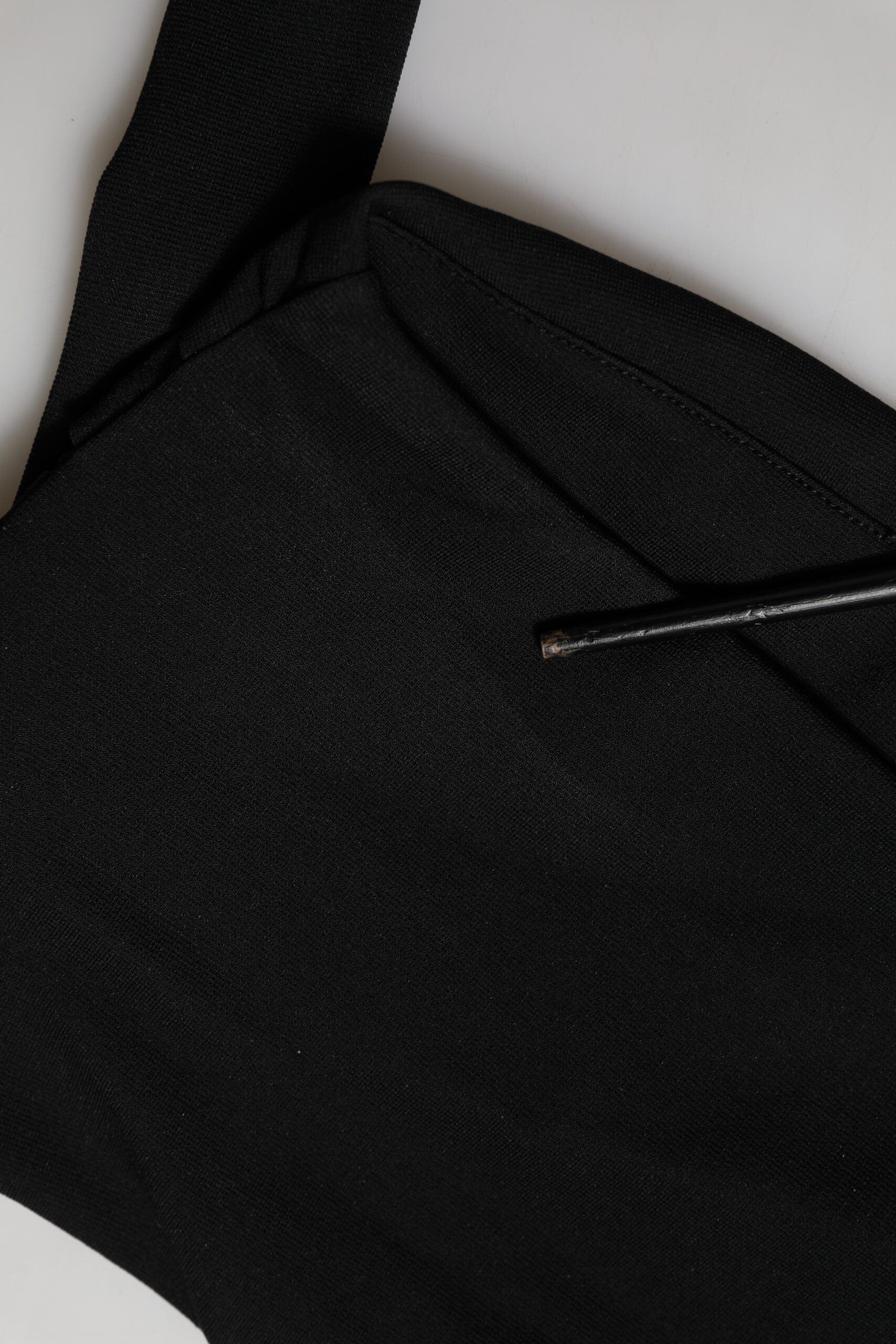 Haut court noir en viscose Dolce & Gabbana avec col montant et style halter, porté en off-shoulder.