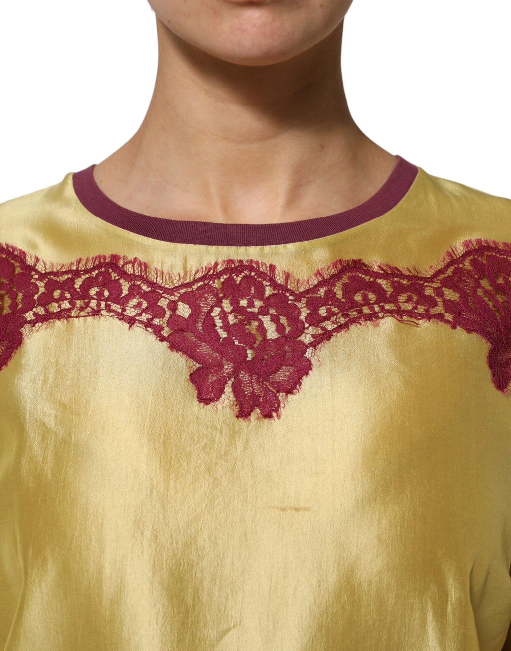 Haut court en soie satin jaune à fleurs et dentelle, manches courtes, de la marque Dolce & Gabbana, visible en gros plan.
