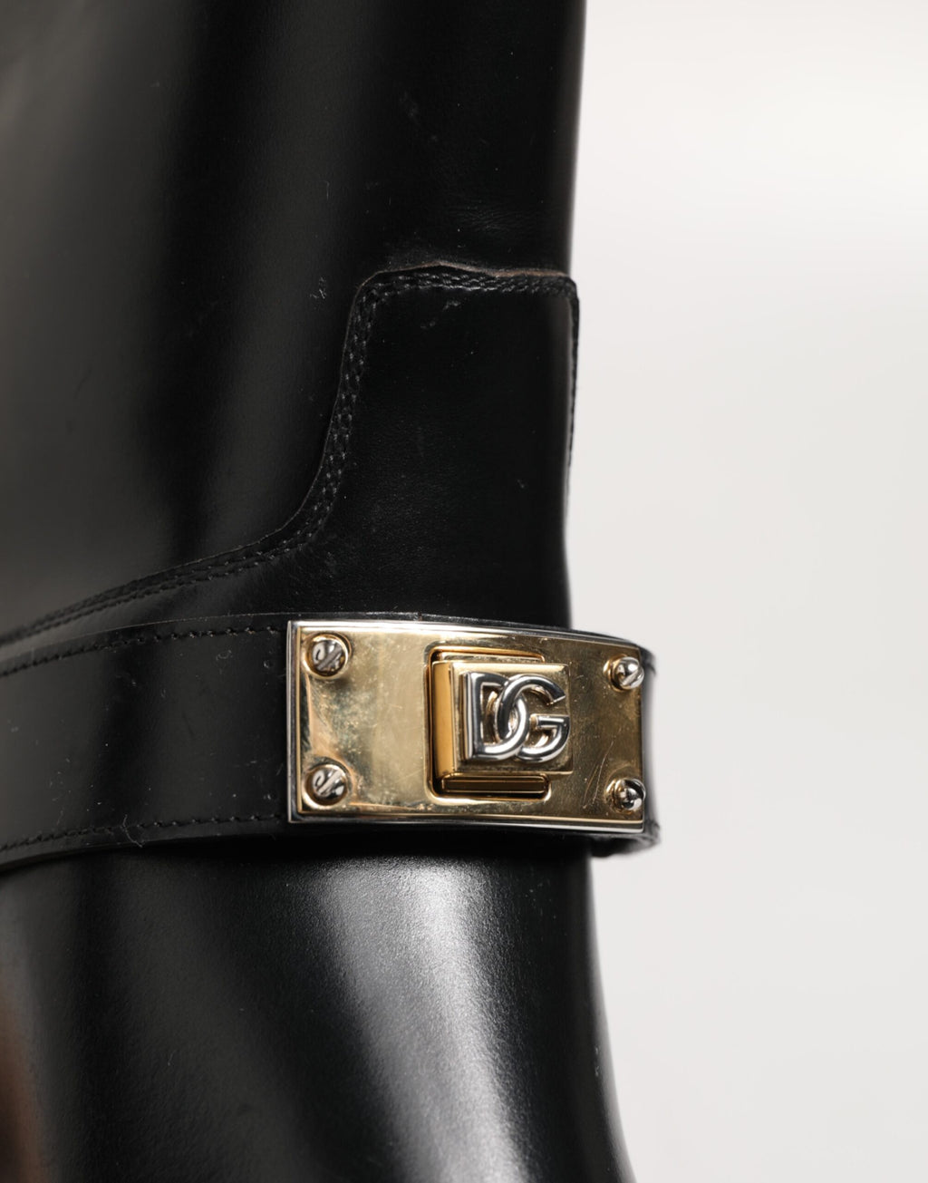 Bottes Dolce & Gabbana noires en cuir avec plaque logo sur le mollet, style élégant et moderne.