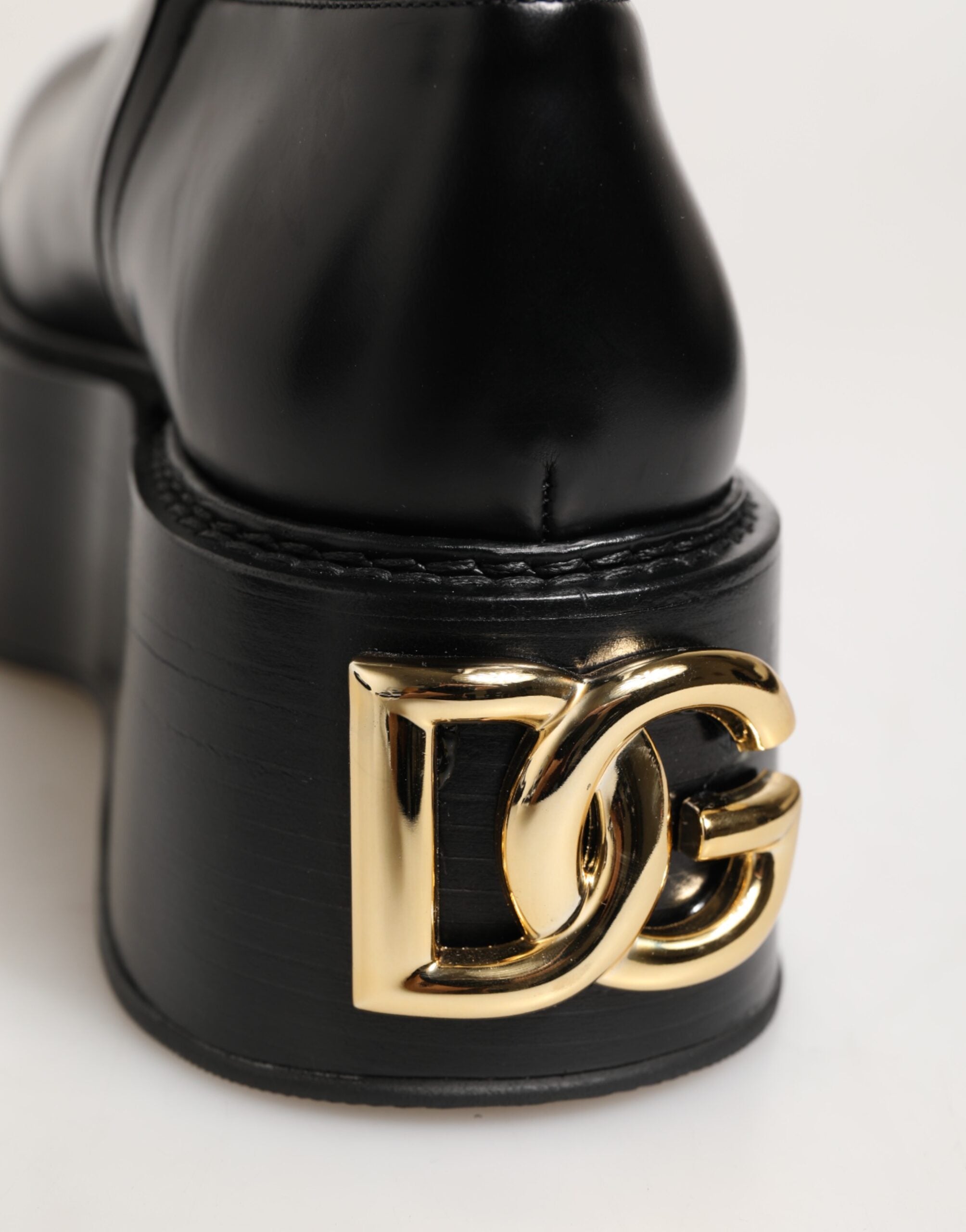 Bottes Dolce & Gabbana noires au genou avec plaque logo, style élégant et sophistiqué, en cuir noir.