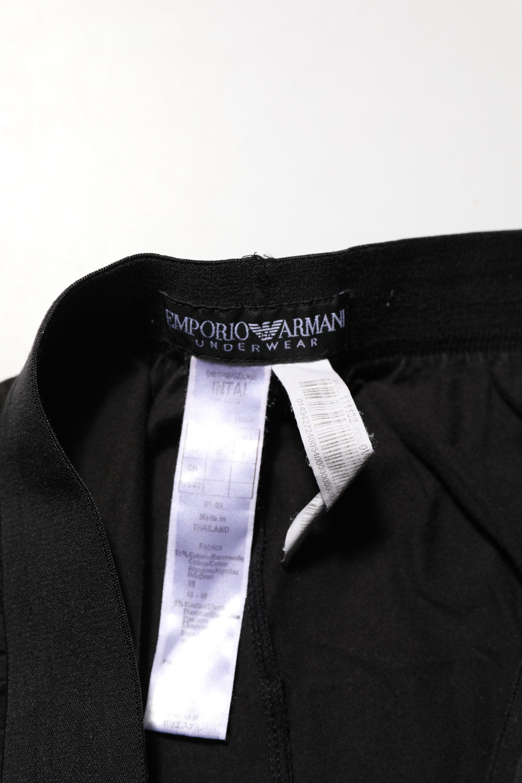Pantalon homme Emporio Armani en coton mélangé noir avec logo sur la ceinture, coupe classique et élégante.