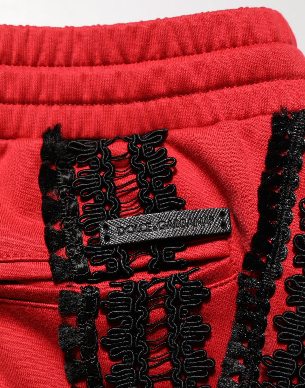 Pantalon cropé décontracté rouge Dolce & Gabbana à broderies, style casual et tendance, visible en gros plan.