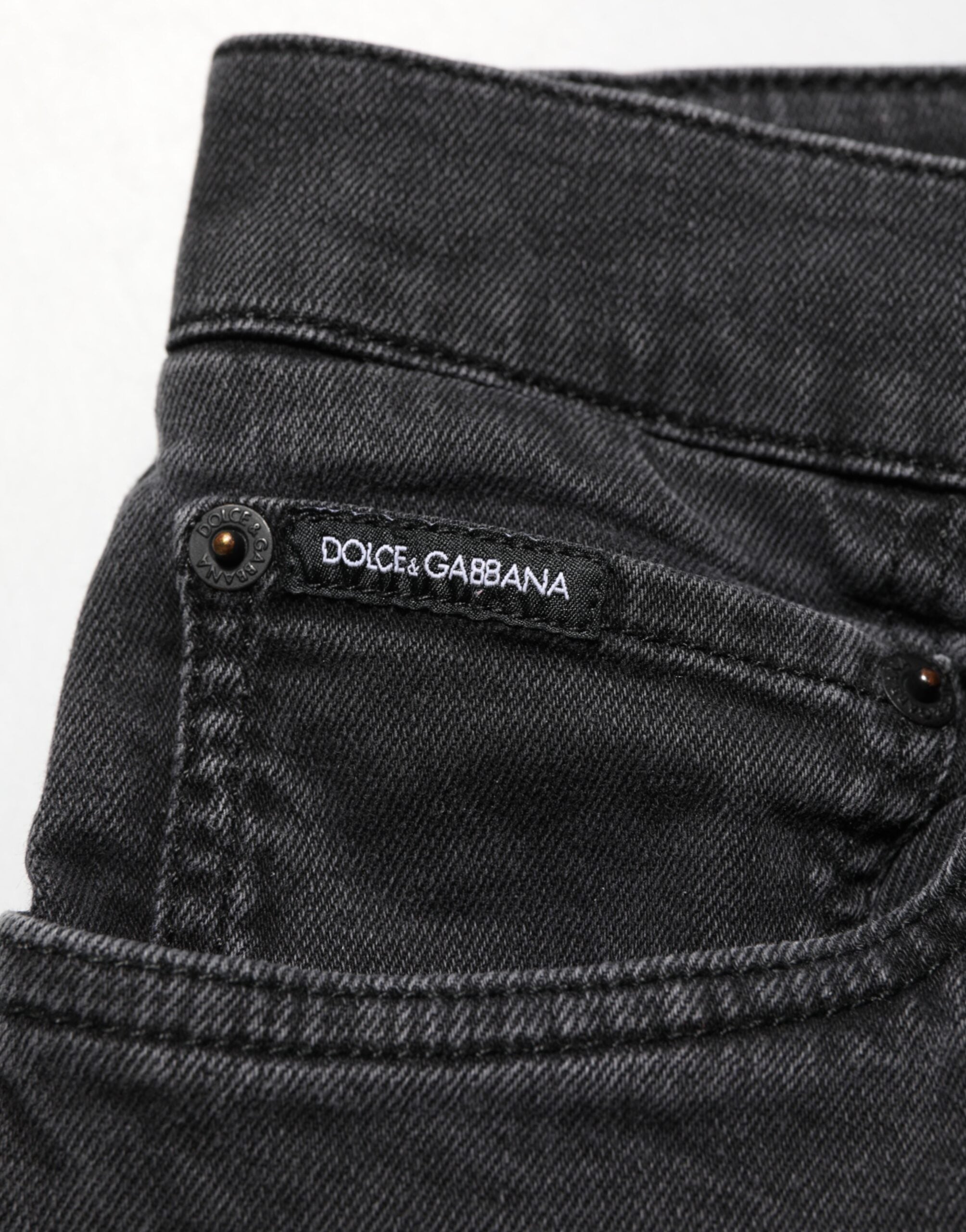 Jeans Dolce & Gabbana en denim gris foncé, coupe slim en coton stretch, visible sur un mannequin avec poches et fermeture éclair.