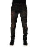 Jeans homme skinny en coton noir Dolce & Gabbana, déchirés et ajustés, avec détails tachetés et usés visibles sur l’image.