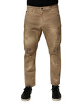 Jeans hommes Dolce & Gabbana en coton beige décontracté avec déchirures et style loose, visible en détail sur l’image.