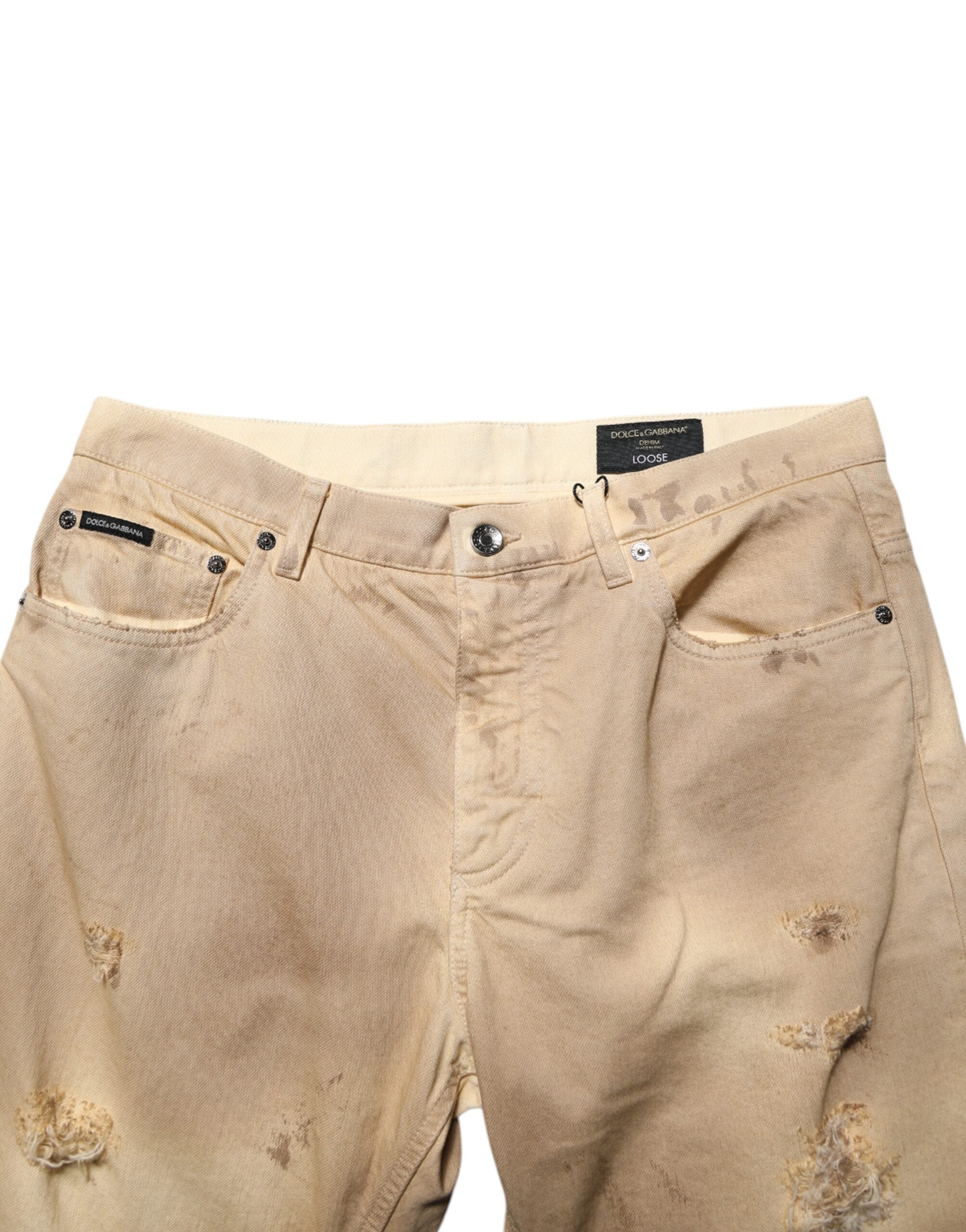 Jeans homme en coton beige déchiré de Dolce & Gabbana, coupe ample et style décontracté, denim tattered.