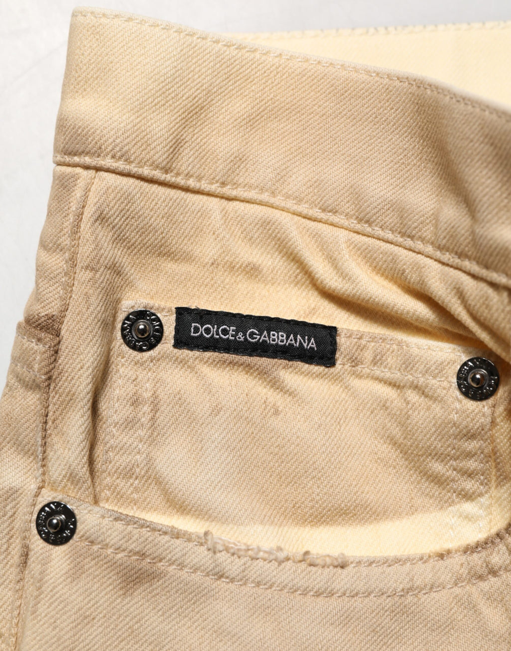 Jeans homme en coton beige déchiré de Dolce & Gabbana, coupe ample et décontractée, style vintage et tendance.