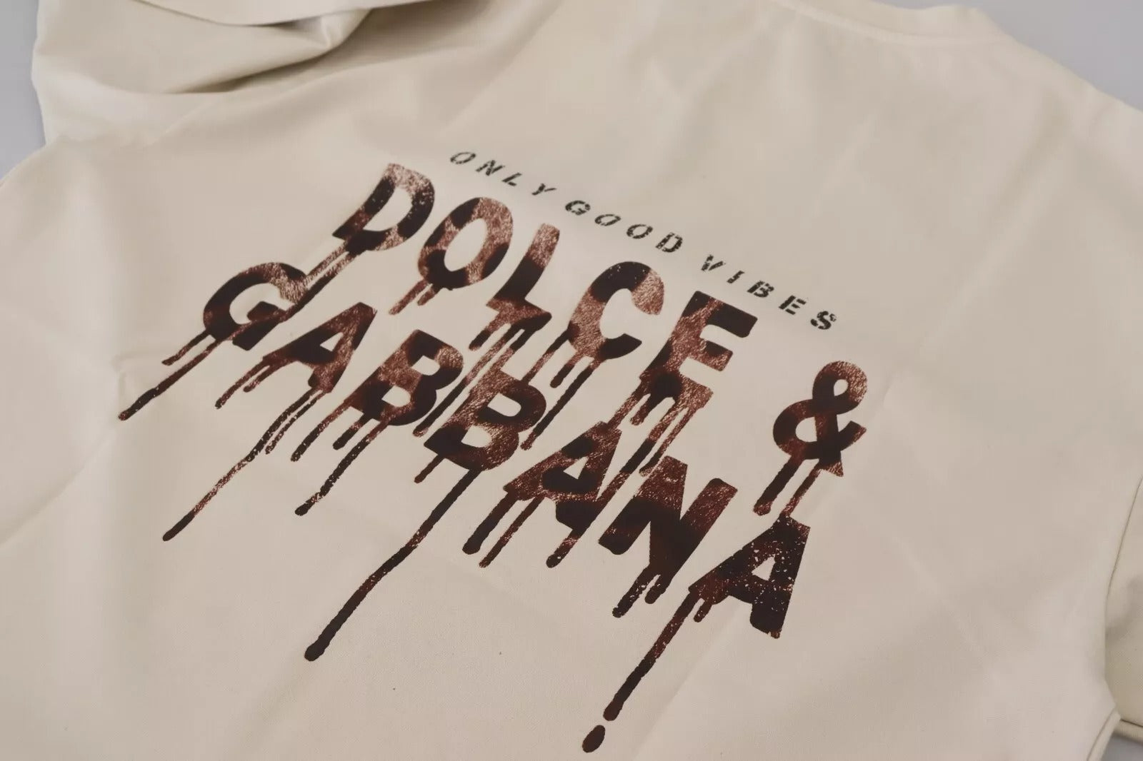 Pull en coton ivoire Dolce & Gabbana à col rond avec imprimé, vue de face sur fond neutre.