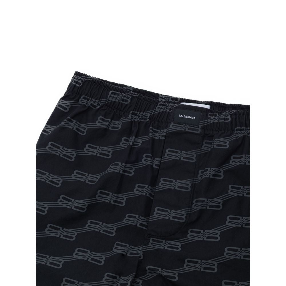 Shorts bermuda en coton noir de Balenciaga, style décontracté, avec logo discret, porté dans une tenue moderne et élégante.