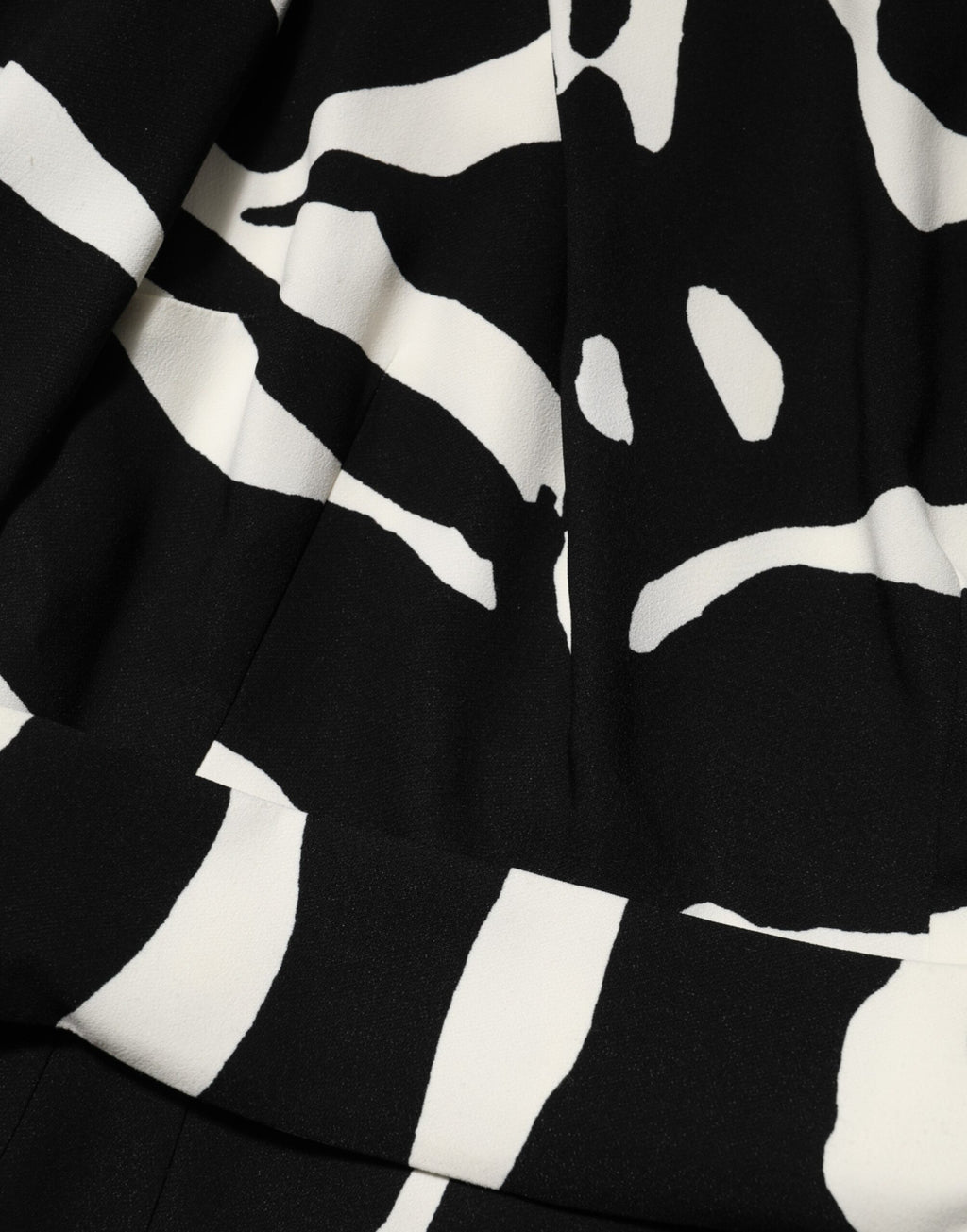 Robe courte noire et blanche Dolce & Gabbana à une épaule avec fente haute, style élégant et sophistiqué.
