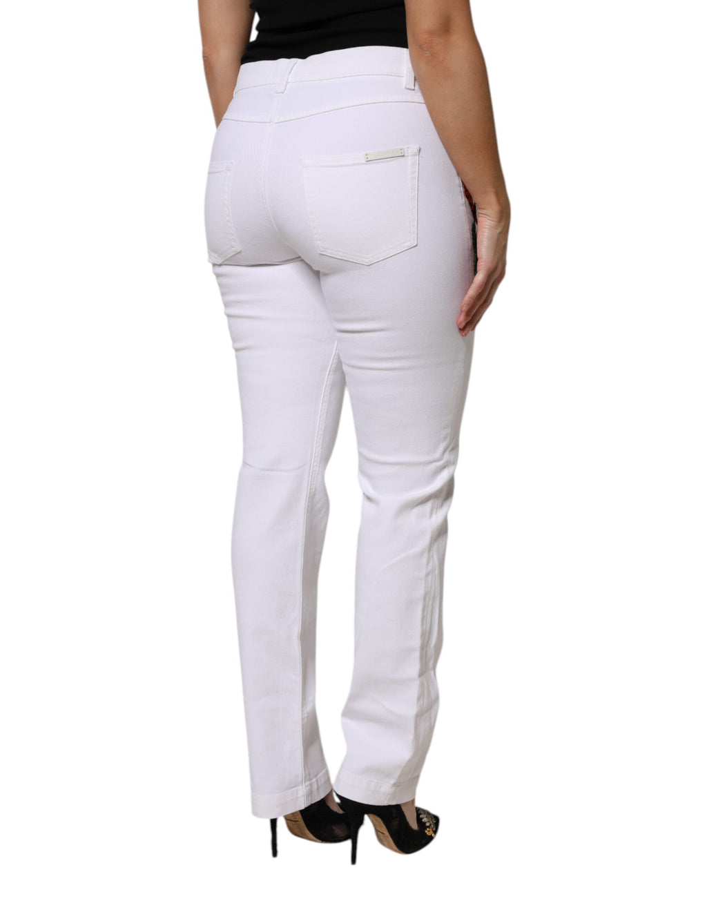 Jeans en denim blanc Dolce & Gabbana avec broderie florale girly, détails élégants et style tendance visible sur l'image.