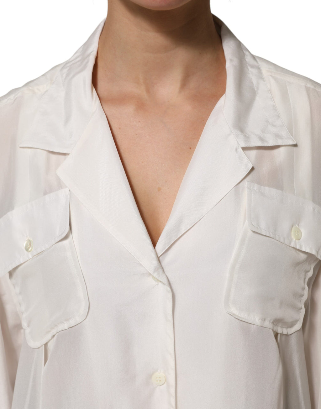 Chemise polo en soie blanche de Dolce & Gabbana, boutonnière élégante et tissu fluide visible sur l'image.