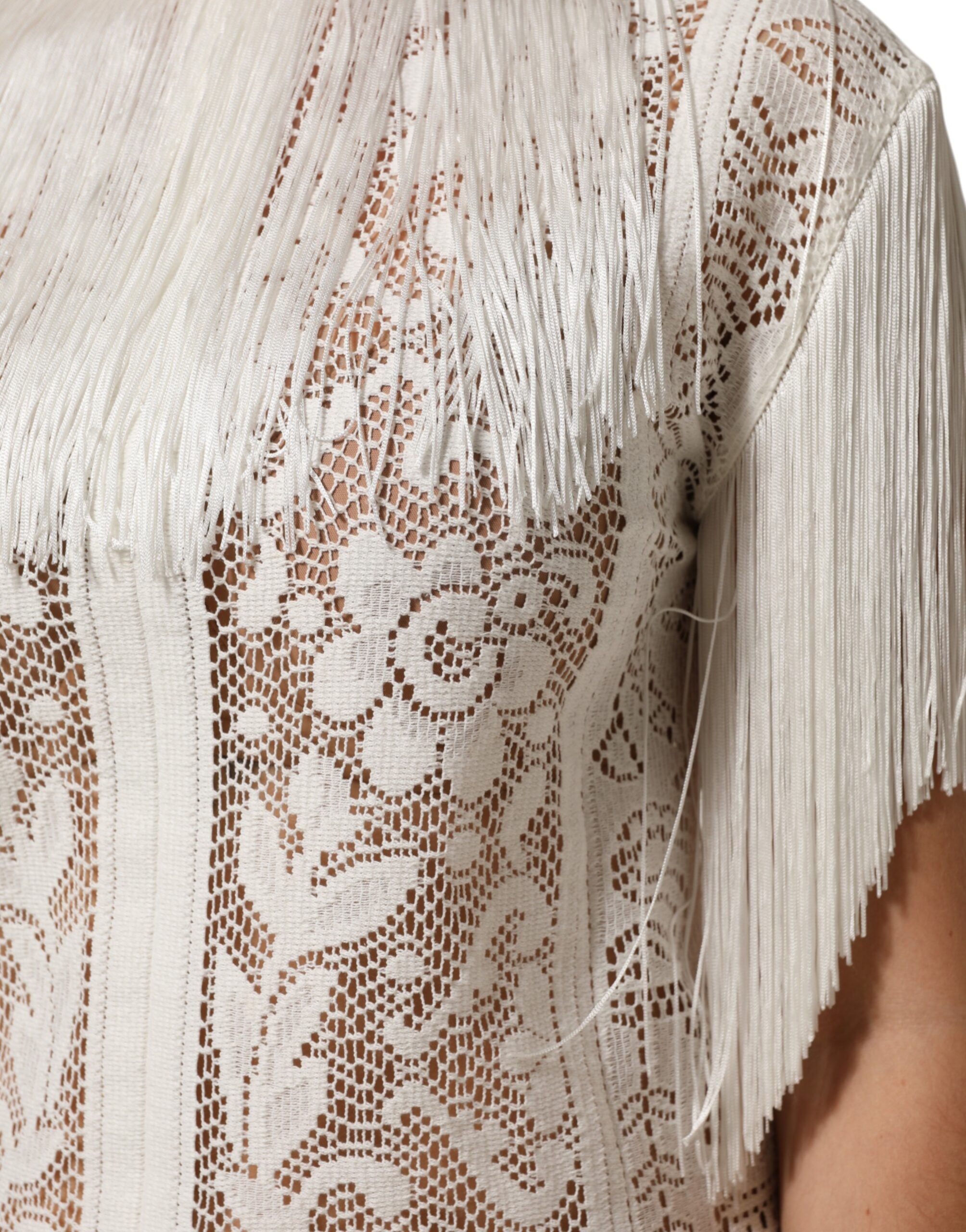 Robe blanche en dentelle florale Dolce & Gabbana, longueur genou avec franges, élégante et sophistiquée.