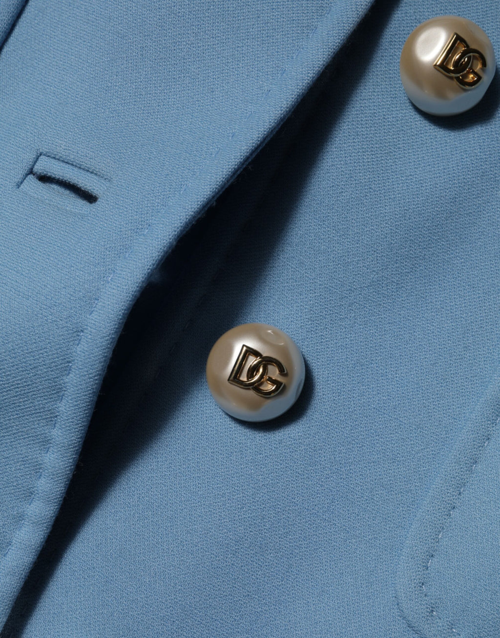 Impression d’un manteau trench bleu Dolce & Gabbana à boutons, veste élégante en tissu léger, vue de face.