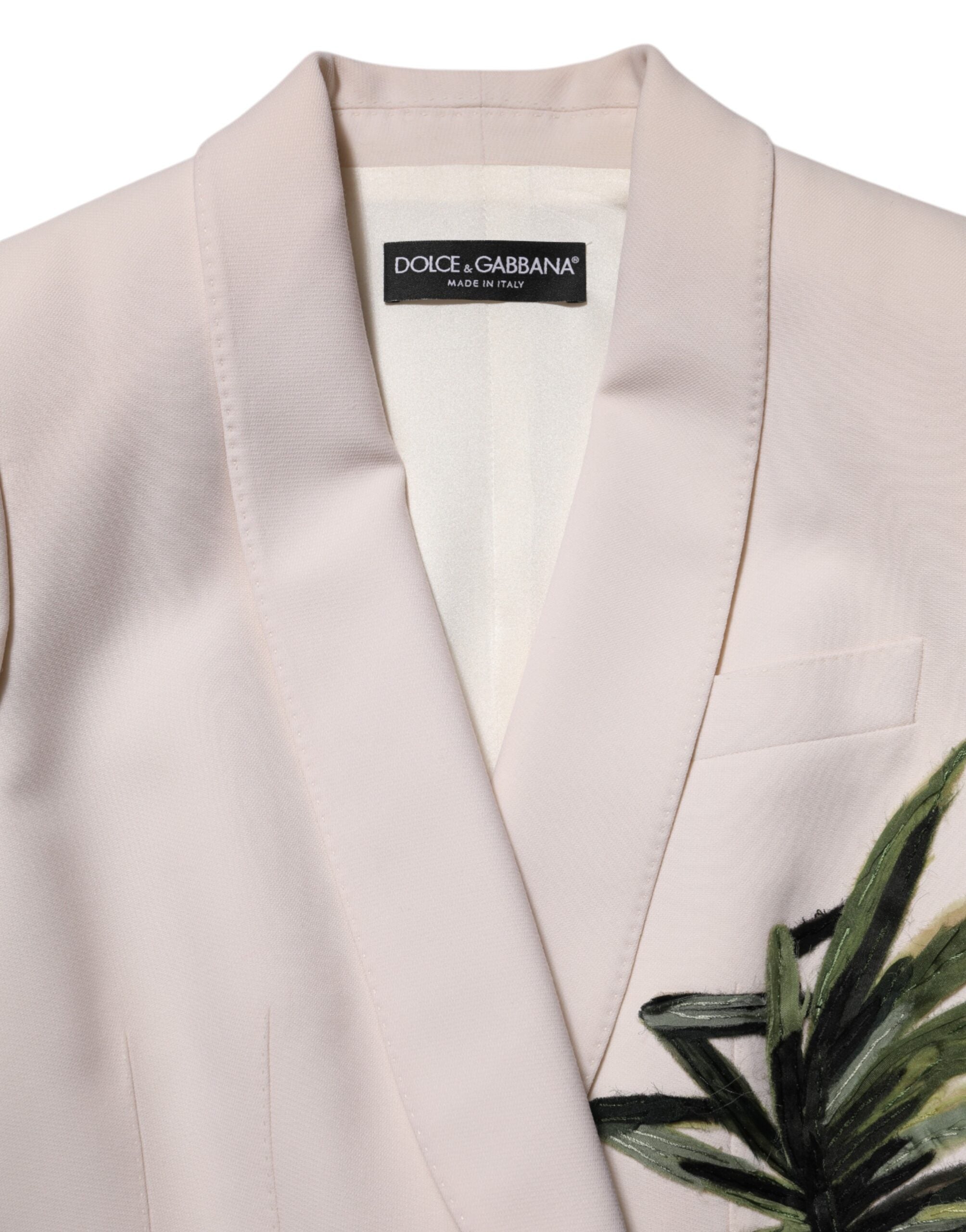 Veste beige Dolce & Gabbana à broderies, à simple boutonnage, élégante et sophistiquée, visible en détail sur l’image.