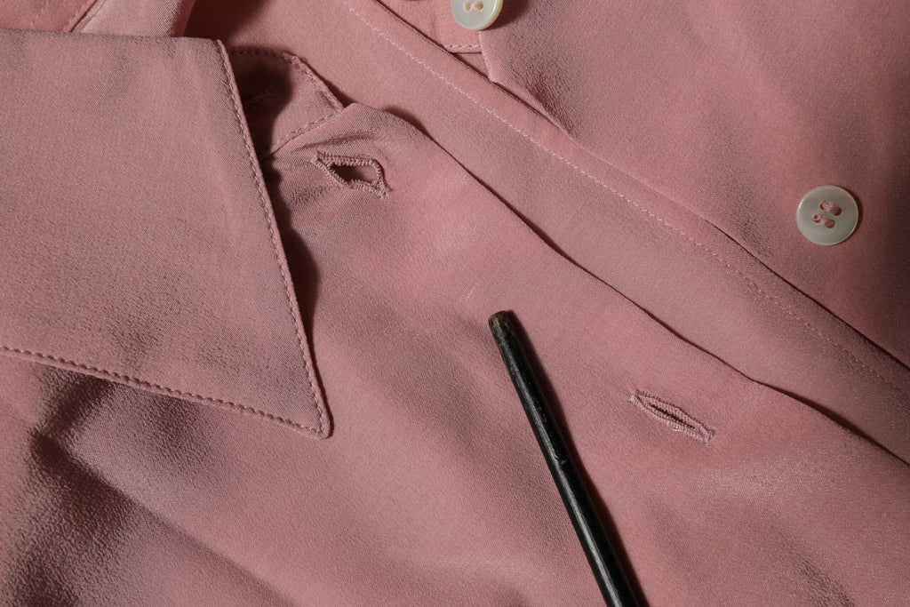 Chemisier en soie rose Dolce & Gabbana à col et manches longues, élégant et sophistiqué, visible avec détails de couture.