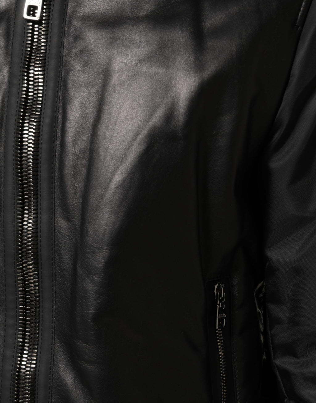 Blouson Dolce & Gabbana en cuir noir et nylon avec fermeture éclair complète, style élégant et moderne.