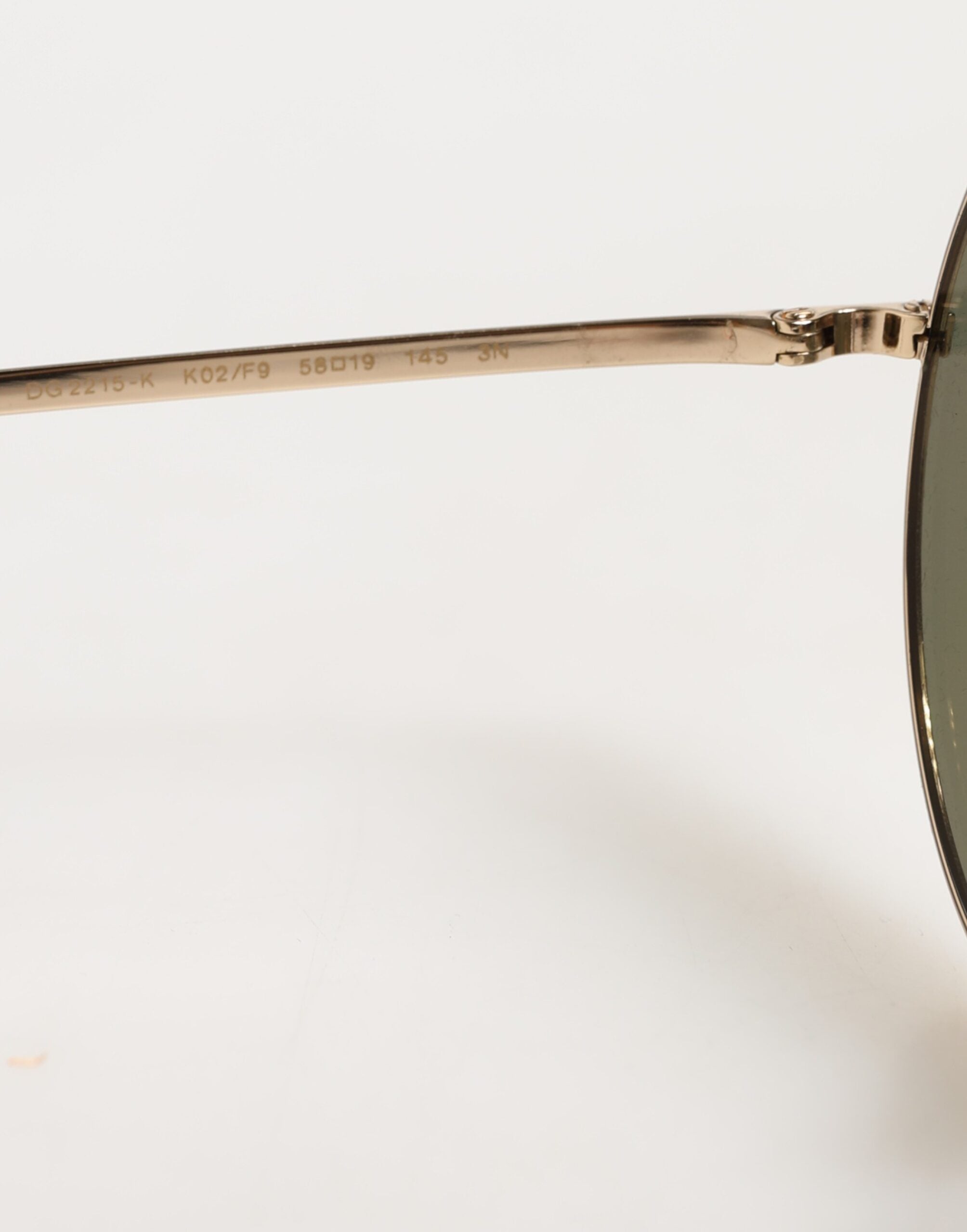 Lunettes de soleil rondes en métal doré de Dolce & Gabbana, style élégant avec monture dorée brillante et verres foncés.