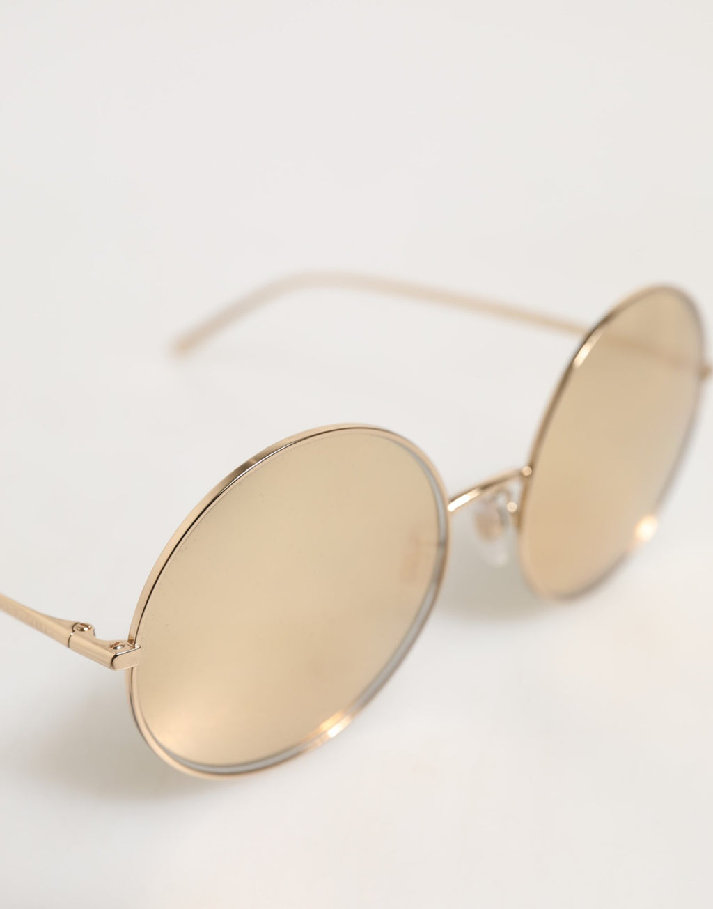 Lunettes de soleil rondes en métal doré Dolce & Gabbana, style élégant et sophistiqué, avec monture fine et verres teintés.