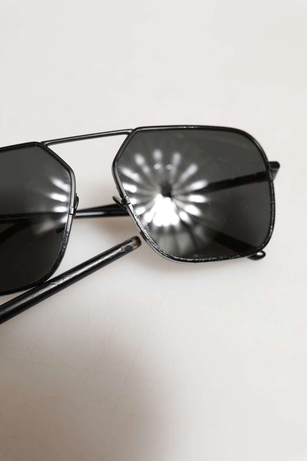Lunettes de soleil Dolce & Gabbana avec monture en métal noir et verres carrés, style élégant et moderne.