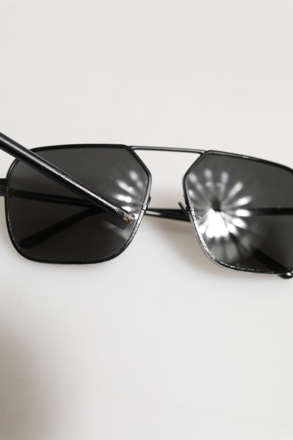 Lunettes de soleil Dolce & Gabbana avec monture en métal noir et verres carrés, style élégant et moderne.