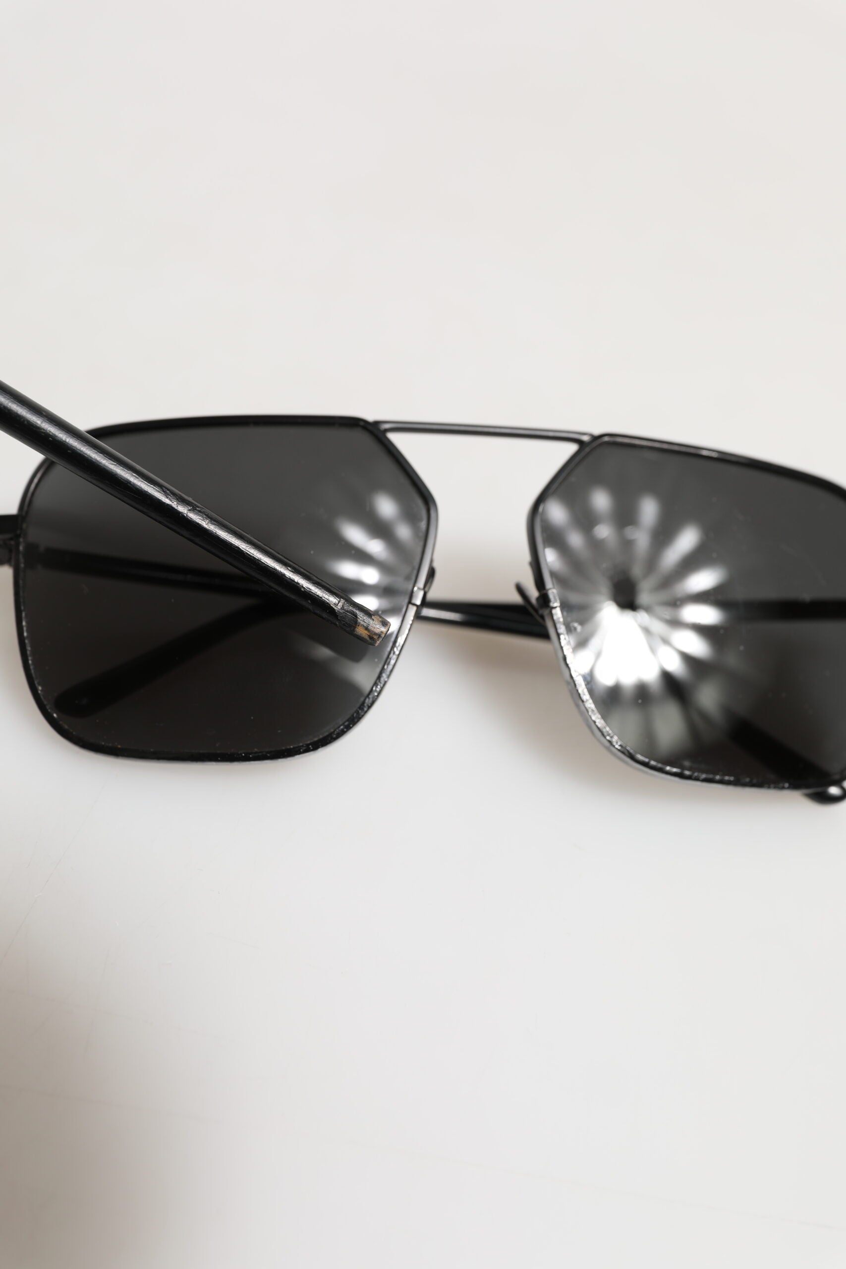 Lunettes de soleil Dolce & Gabbana avec monture en métal noir et verres carrés, style élégant et moderne.