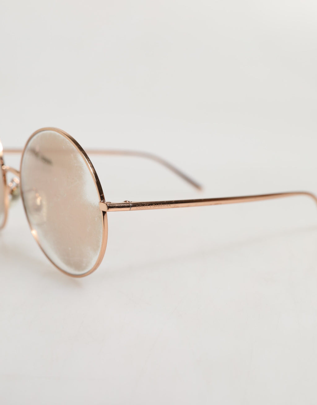Lunettes de soleil Dolce & Gabbana avec monture ronde plaquée or rose et verres de style classique.
