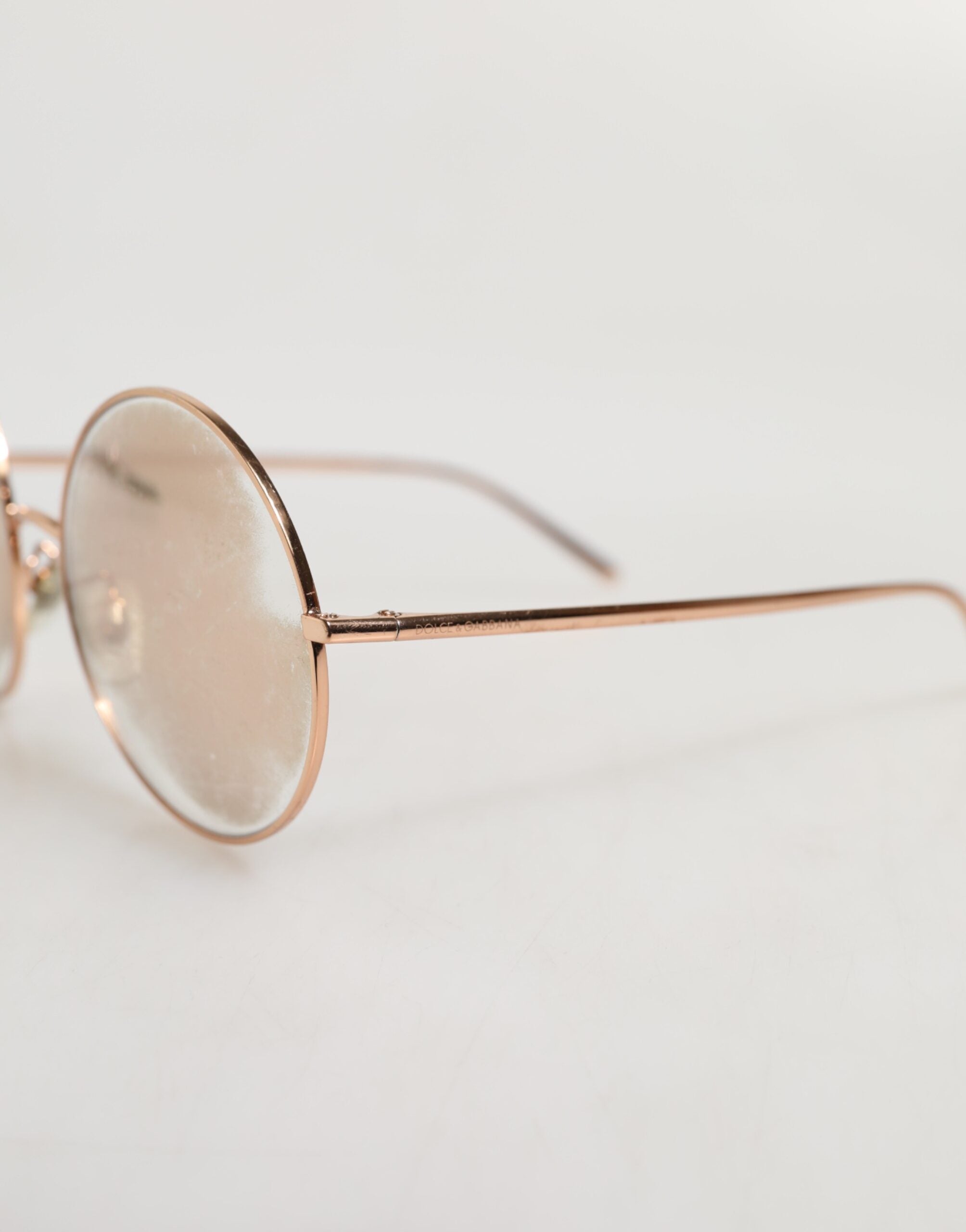 Lunettes de soleil Dolce & Gabbana avec monture ronde plaquée or rose et verres de style classique.