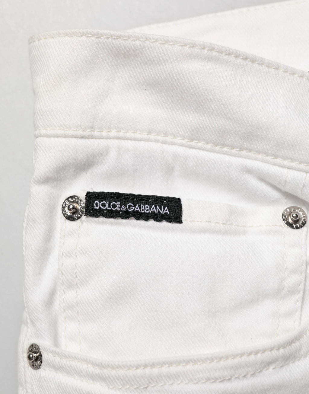 Jeans slim Dolce & Gabbana en denim blanc avec imprimé graffiti orné de détails dorés.