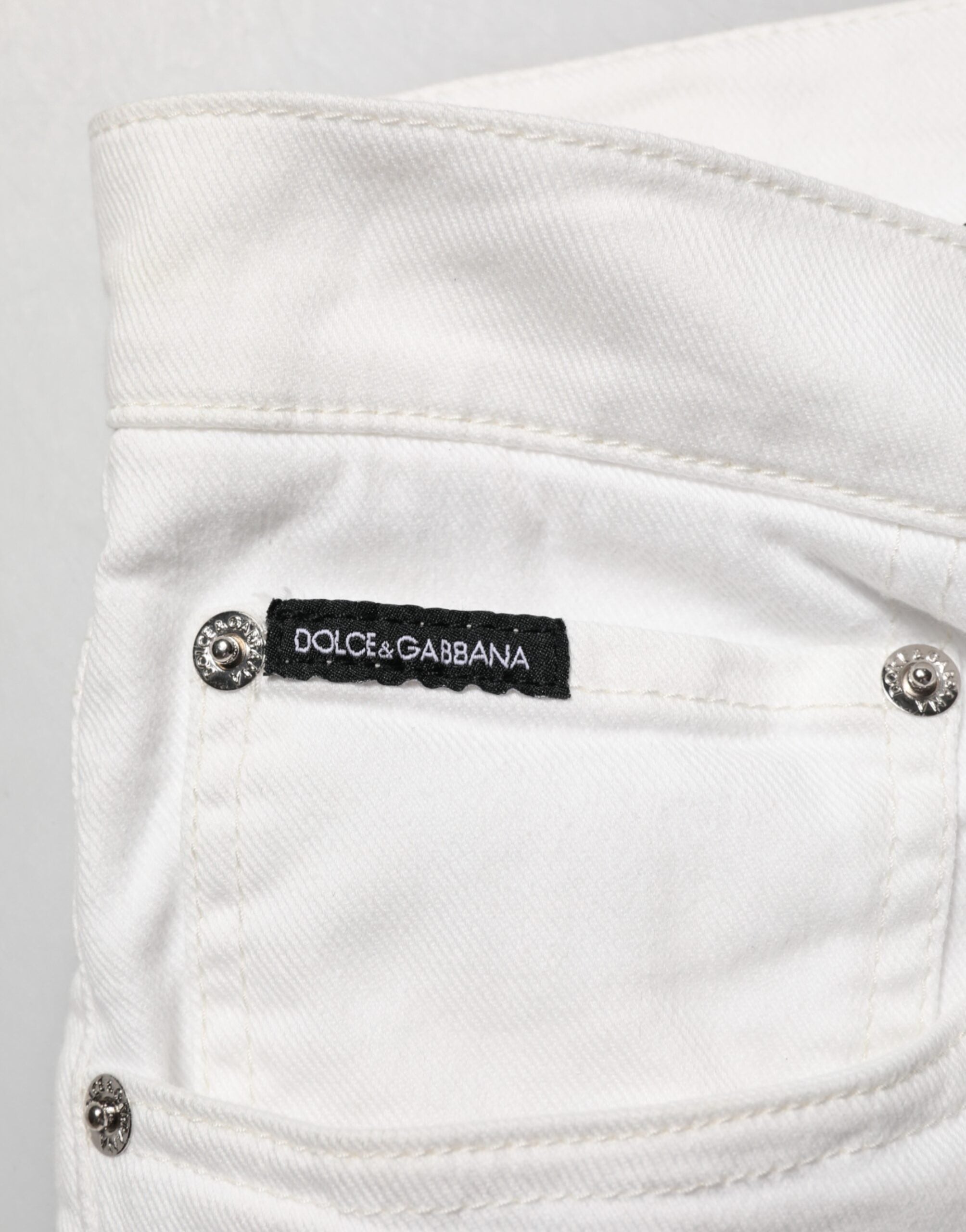 Jeans slim Dolce & Gabbana en denim blanc avec imprimé graffiti orné de détails dorés.