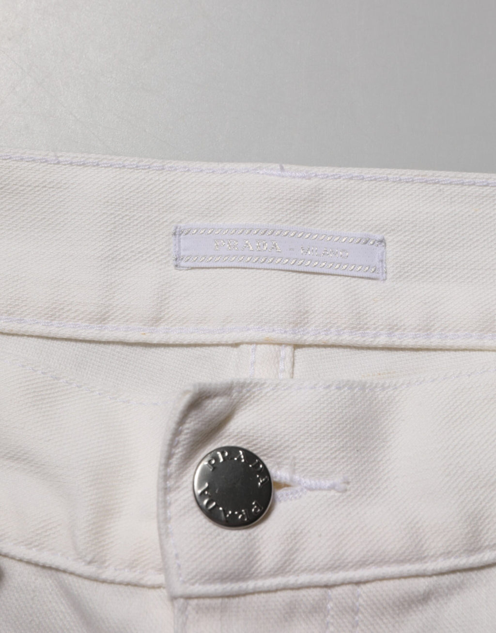 Jeans Prada blancs taille moyenne, coupe skinny, en denim décontracté, visibles sur cette image.