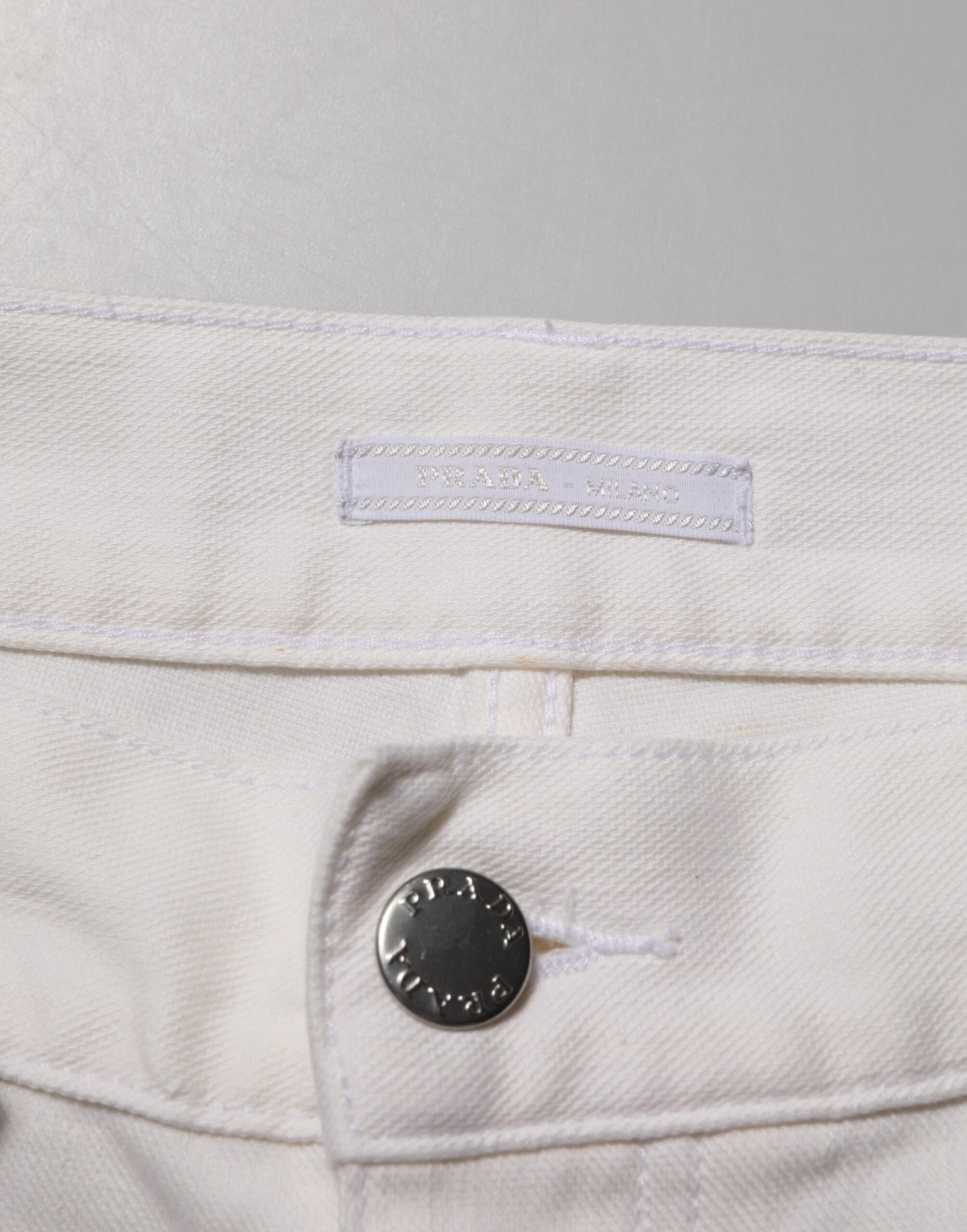 Jeans Prada blancs taille moyenne, coupe skinny, en denim décontracté, visibles sur cette image.